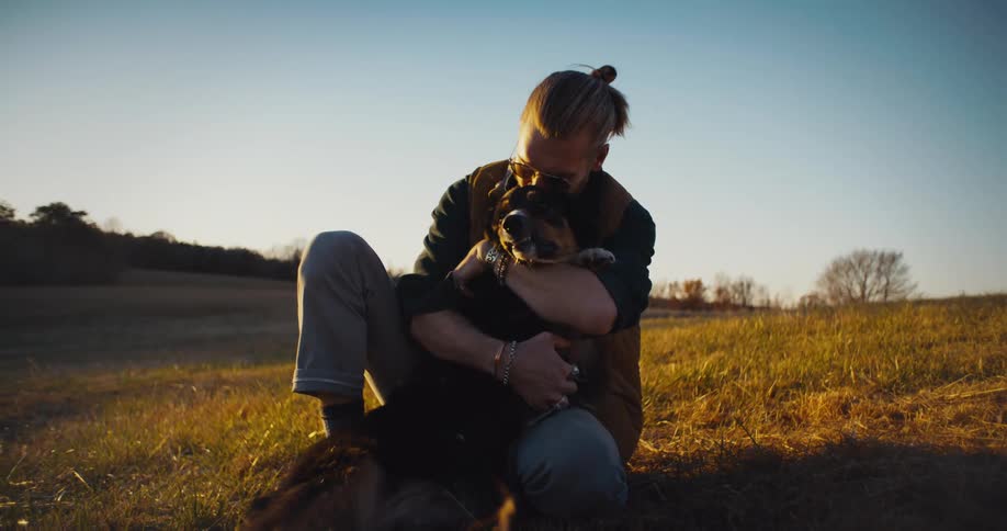 Man in a field hugging a dog