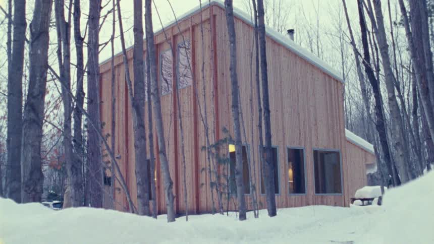 Wooden house surrounded by trees in a snowcovered landscape