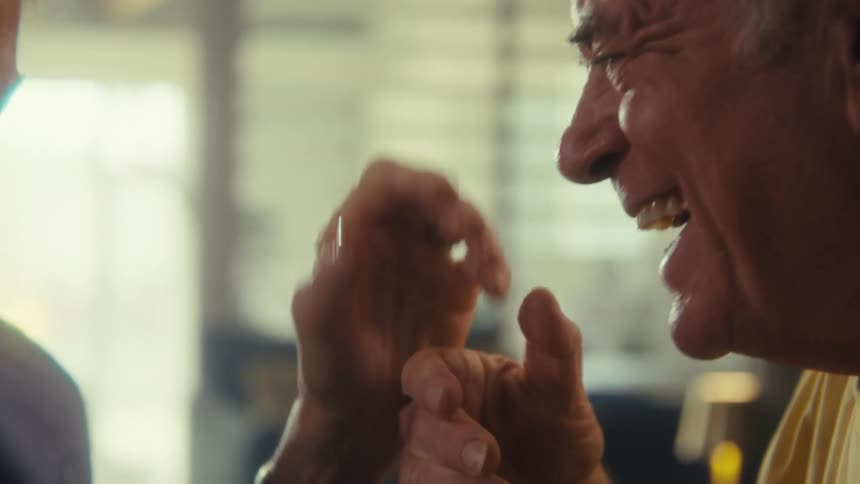 Closeup of an older man embracing and kissing a woman hand