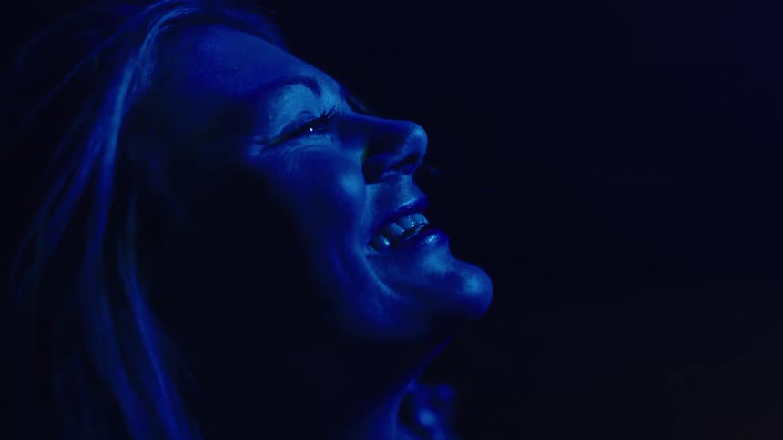 The woman is dancing in the dark room