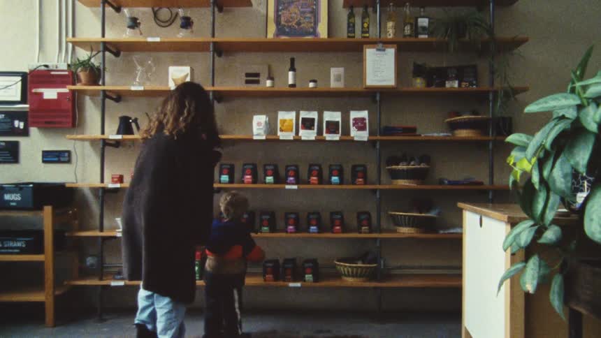 A mother and child are looking at products on shelves in a store