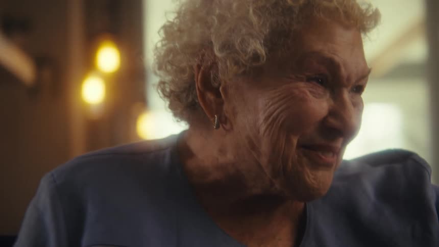 Woman leans forward smiling and talking