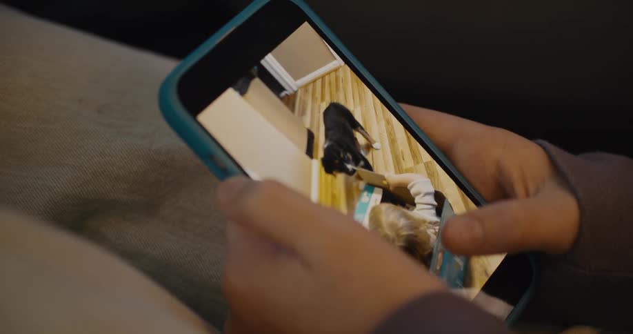 A person scrolls through pictures and videos on a smartphone