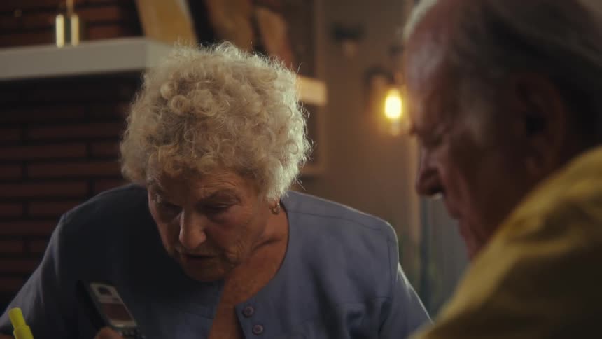 The woman is using a marker as the man uses a calculator