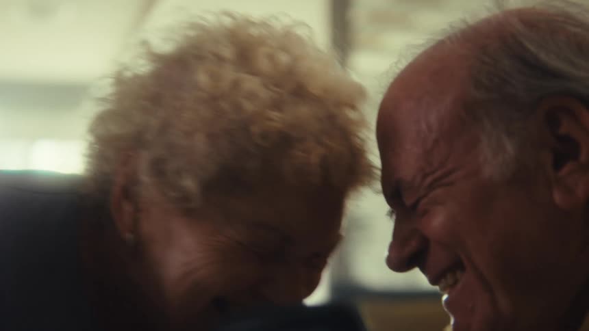 Elderly couple touching foreheads and smiling in an affectionate moment