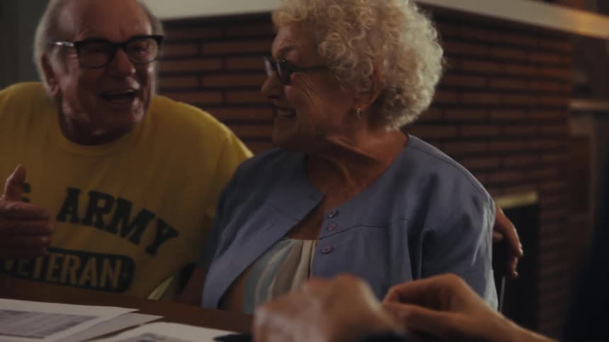 A couple shake hands with a man in their home