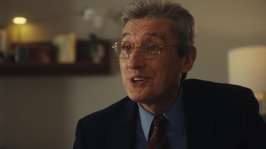 A man in formal attire talking to someone