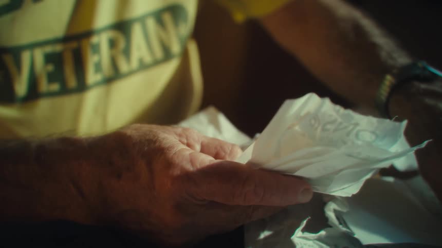 Elderly hand holds crumpled papers