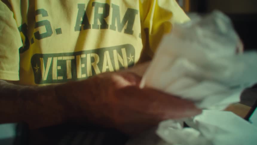 Mans hand holding bills and receipts on the table
