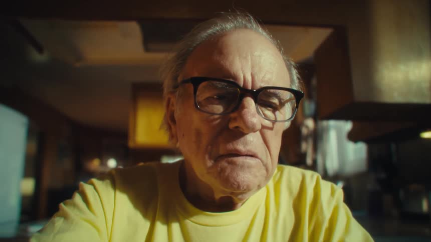 Elderly man putting on glasses and analyzing document papers