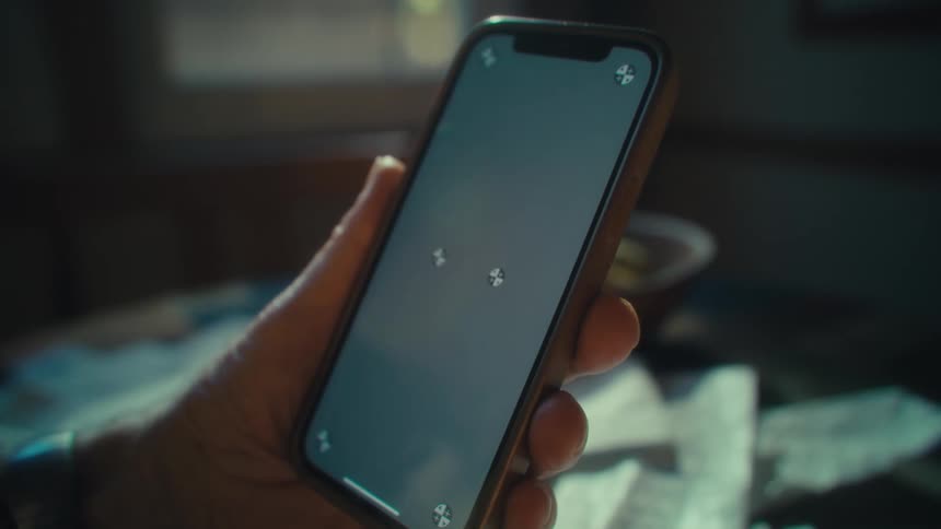 Close up of a person surrounded by crumbled papers facetiming on a cell phone