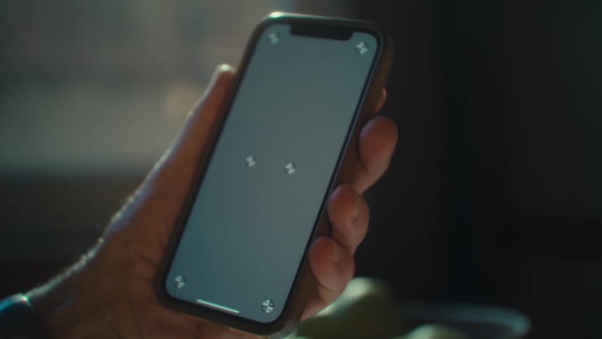 Elderly persons hands holding a smartphone and tapping on the screen