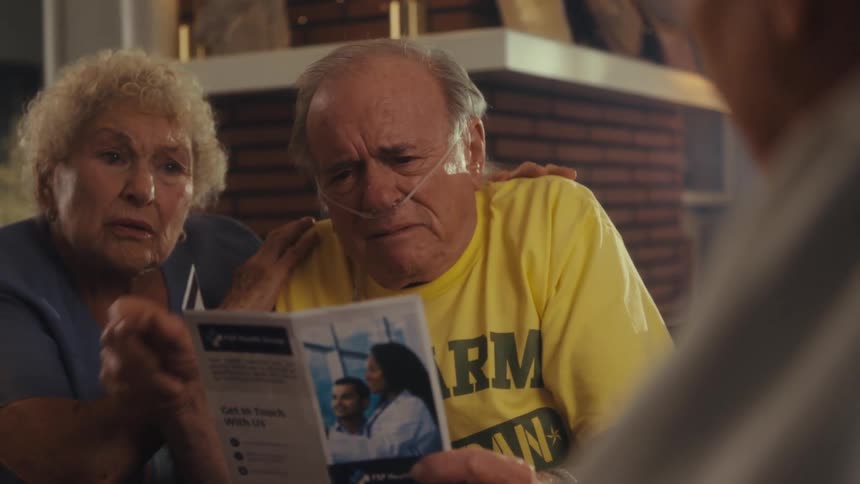 Elderly couple attentively looking at a medical brochure during a consultation