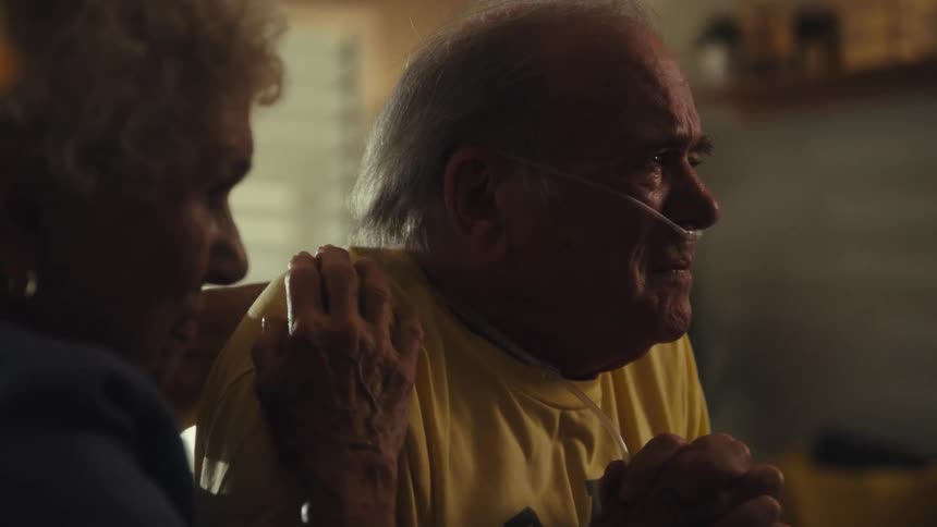 A doctor consoles a crying patient at home