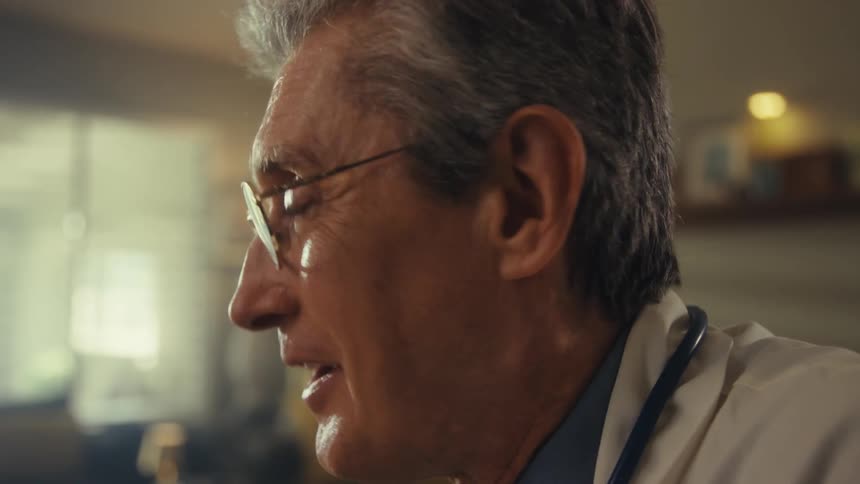 Doctor smiles during a conversation in a closeup side view
