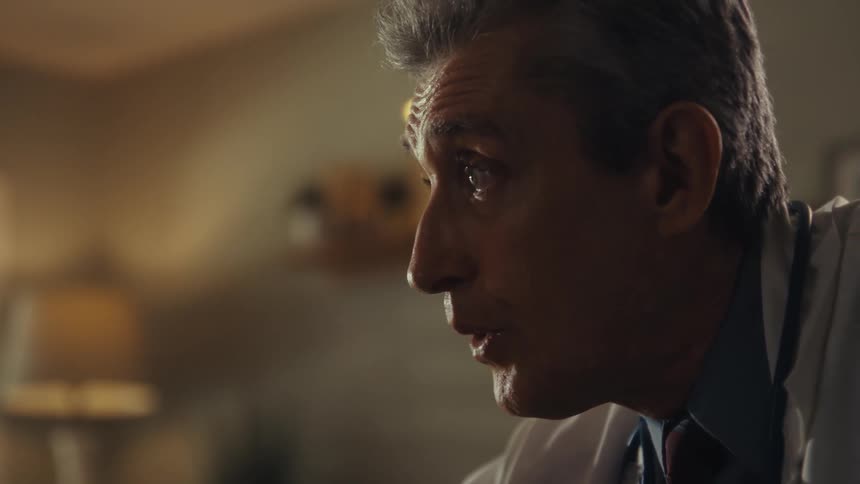 A man tears up as a doctor speaks to him