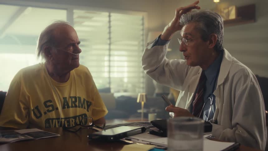 A doctor provides home healthcare to an elderly patient
