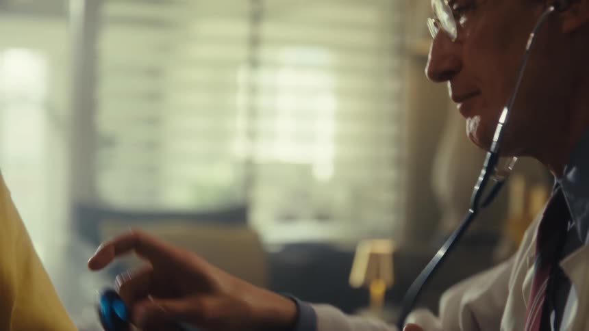 A doctor using a stethoscope to check an elderly mans heartbeat