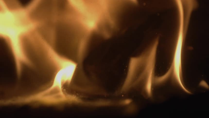 Close up of objects in burning flames at night