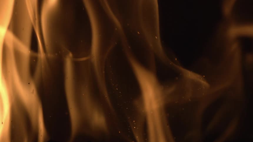 Close up of flames rising at night in slow motion