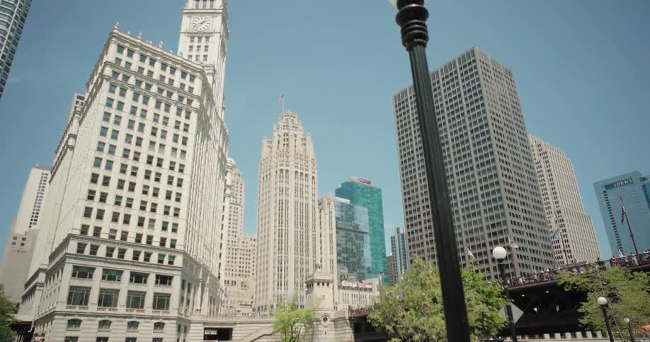 The video shows a busy urban scene with multiple tall buildings under a clear blue sky a sign that reads marketplace is prominent in the foreground
