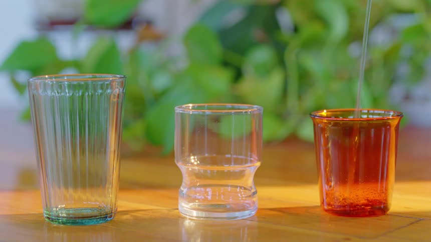 Water is poured into empty glasses on the table