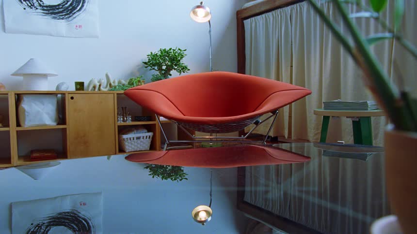 Red armchair in a room decorated with wooden furniture and plants