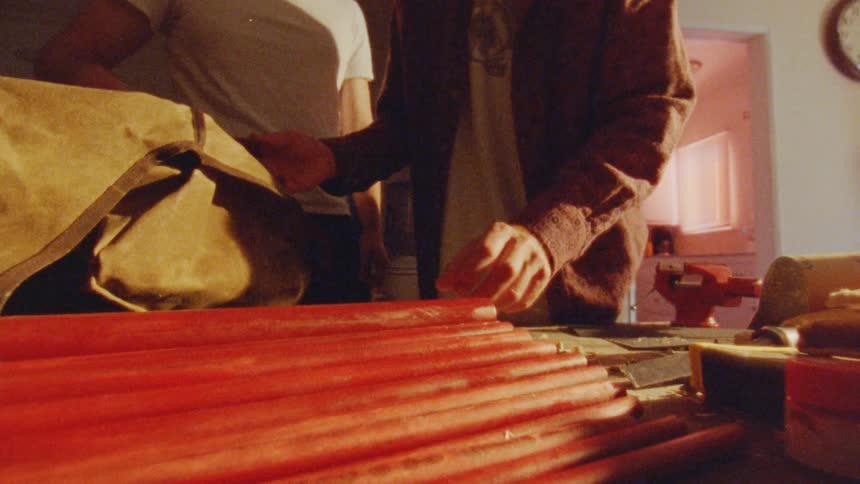 People handling red rods on a table in an indoor setting