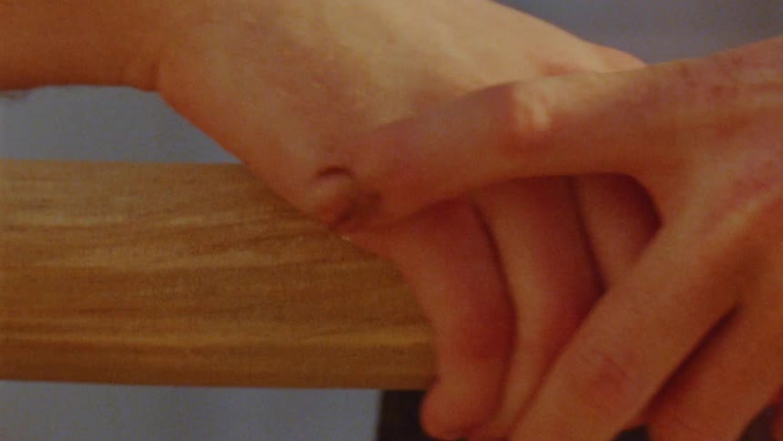 Two hands intertwine in a gesture of affection and closeness