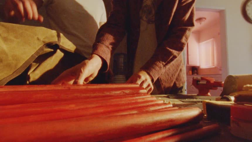 Two people are picking out sticks in the workshop