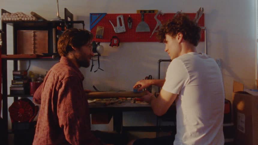 Two men work together on a woodworking project in the workshop