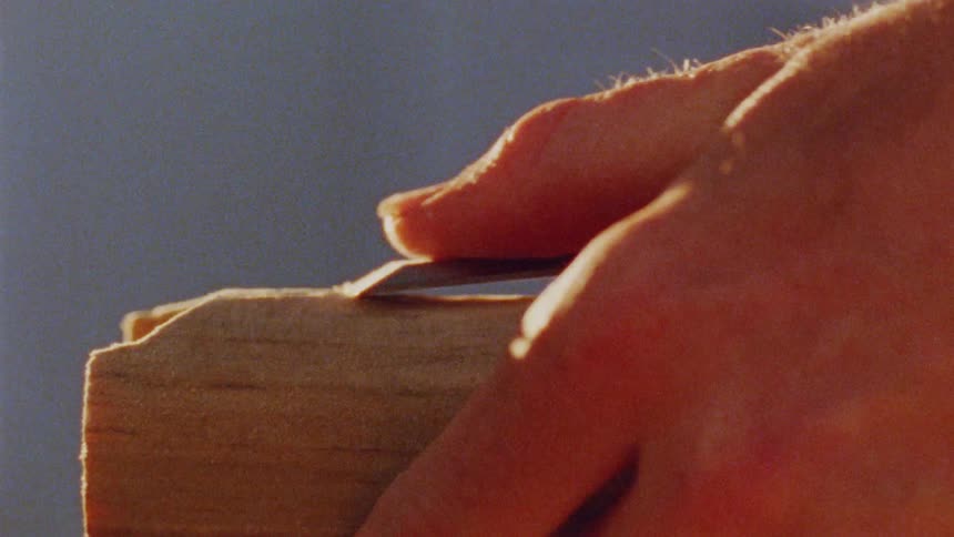Hand with a tool carving a wood