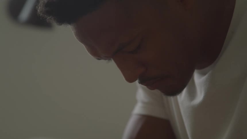 The man is leaning forward with his eyes closed
