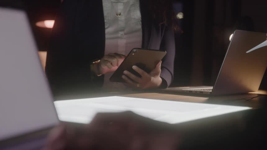Person in business attire uses a tablet at a desk