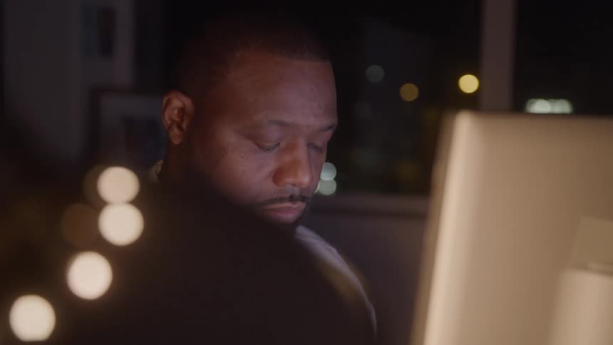 Man in suit and tie works on the computer at night