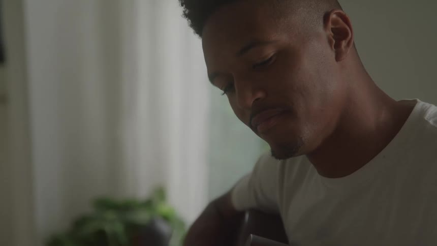 The man is smiling as he plays the guitar