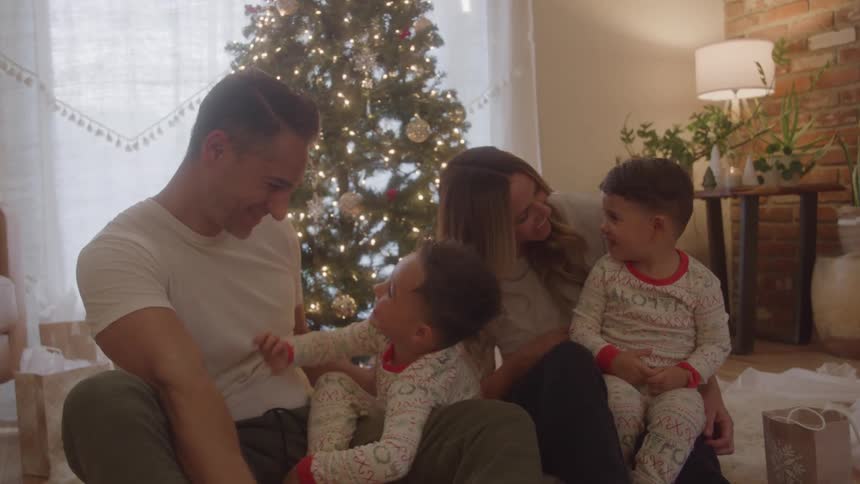 Family sharing happy moments by a christmas tree in the living room