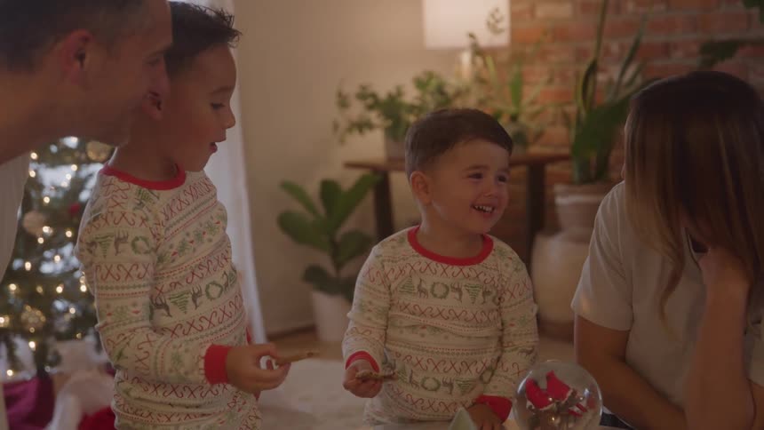 A happy family celebrates christmas as kids enjoy treats