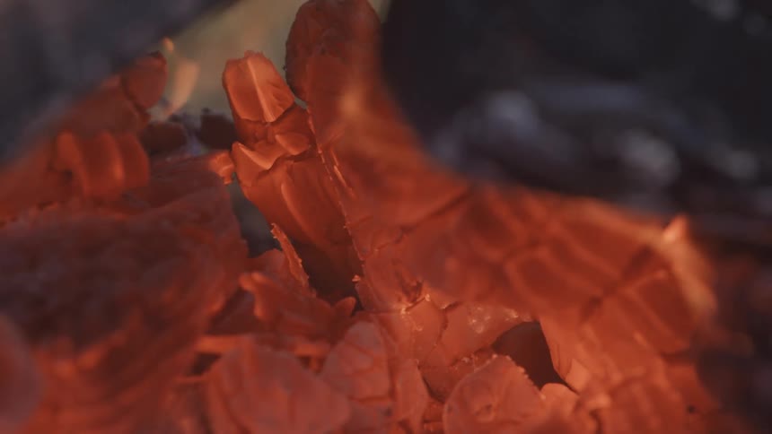 Flames engulf a piece of wood in a bonfire