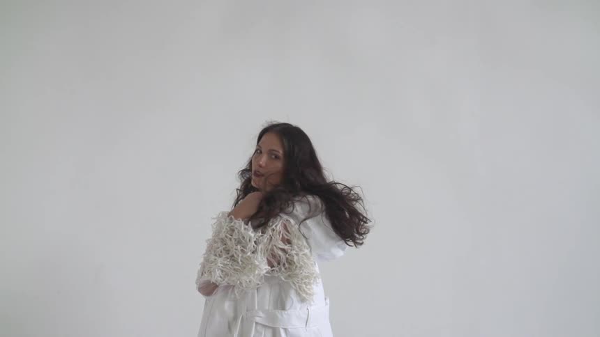 Woman wearing white turns back and forth