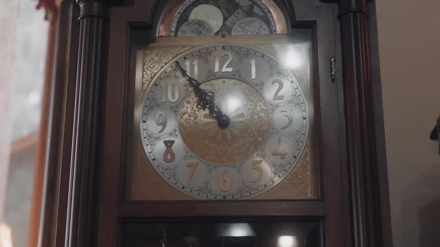 An ornate grandfather clock shows the time as 1155 with intricate silver and gold detailing on its face
