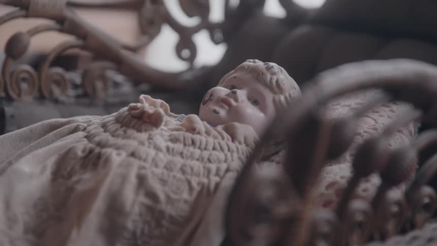 Close up of a baby statue laying on a chair in a room during daytime
