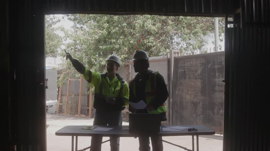 Two employees work together on a construction project