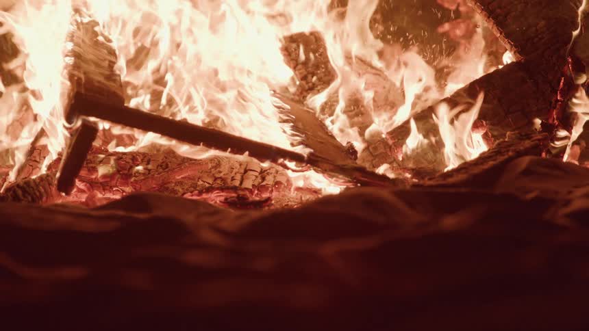 Wood fire burning in the sand at night