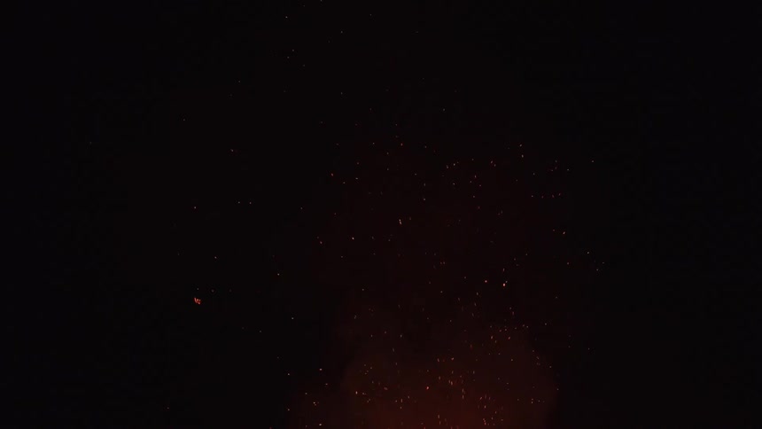 Ash flies up from a fire out of shot