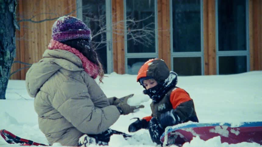 A mother and son through snow at each other