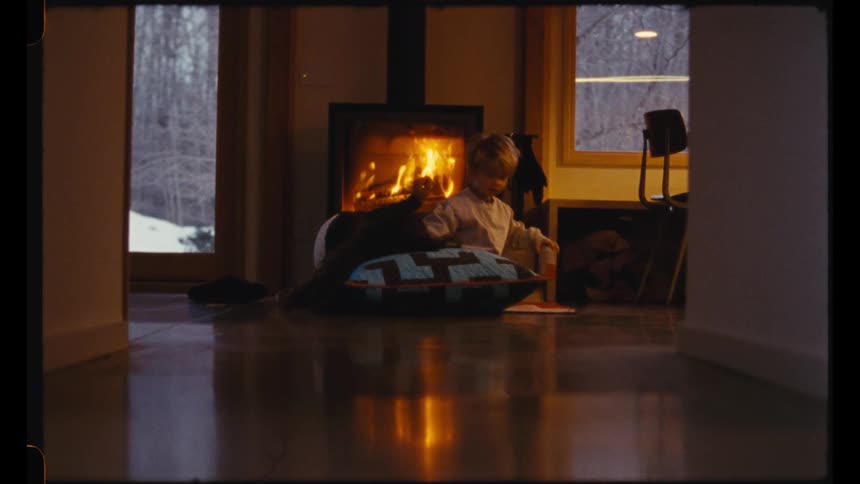 A mother and son lay and sit by the fireplace