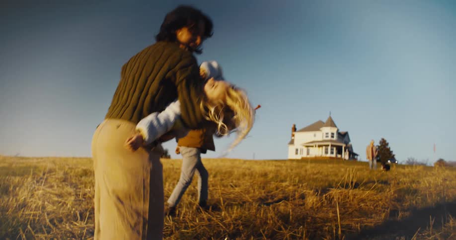 A mother carries her daughter to the house