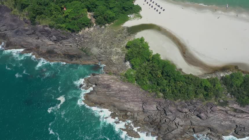 Aerial view of tropical beach with rocks and turquoise sea