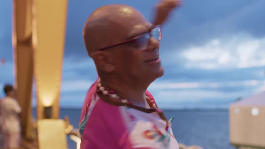 A man spins around dancing on the boardwalk